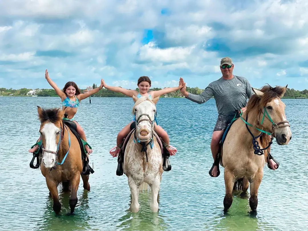 A father enjoying the horse riding with his two daughter